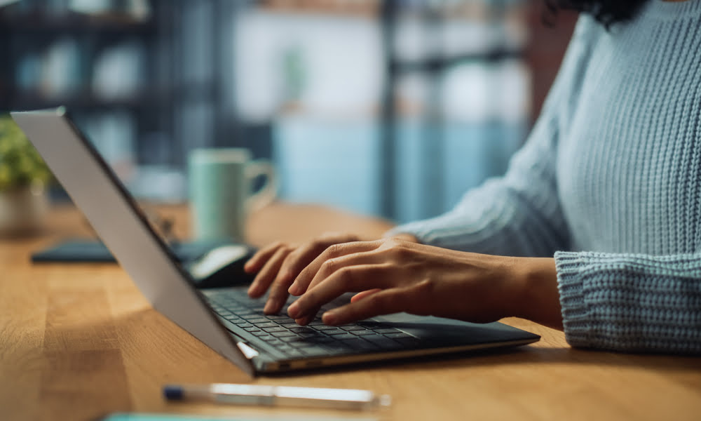 closeup_on_hands_woman_working_on_laptop_at_cozyhome_as_428958176